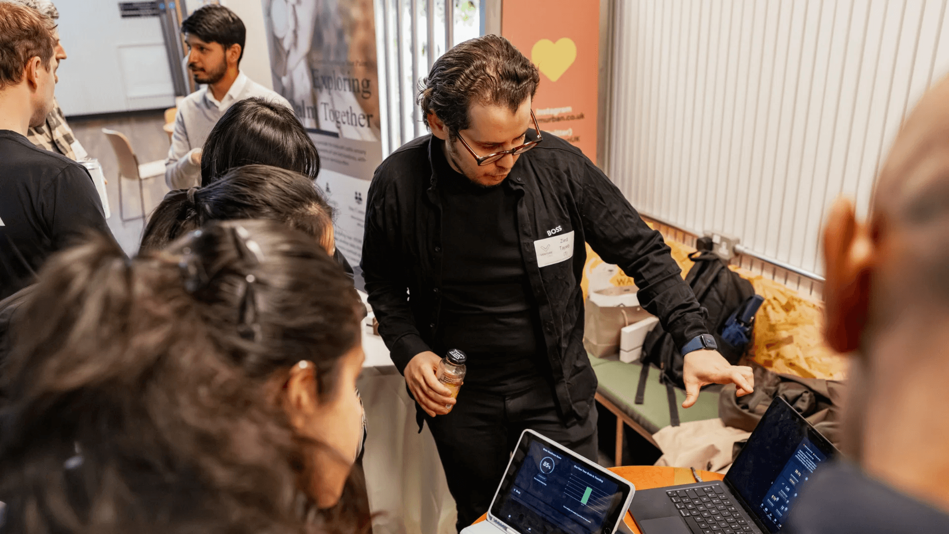 Man teaches workshop and looks at other people's screens.