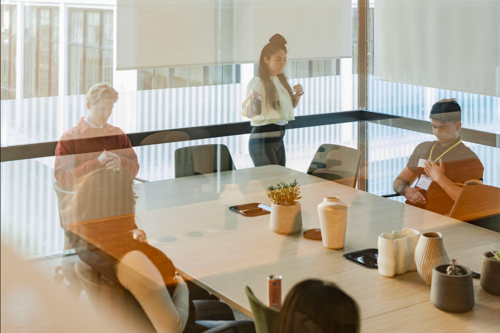Shot through the window of the boardroom with people using the space