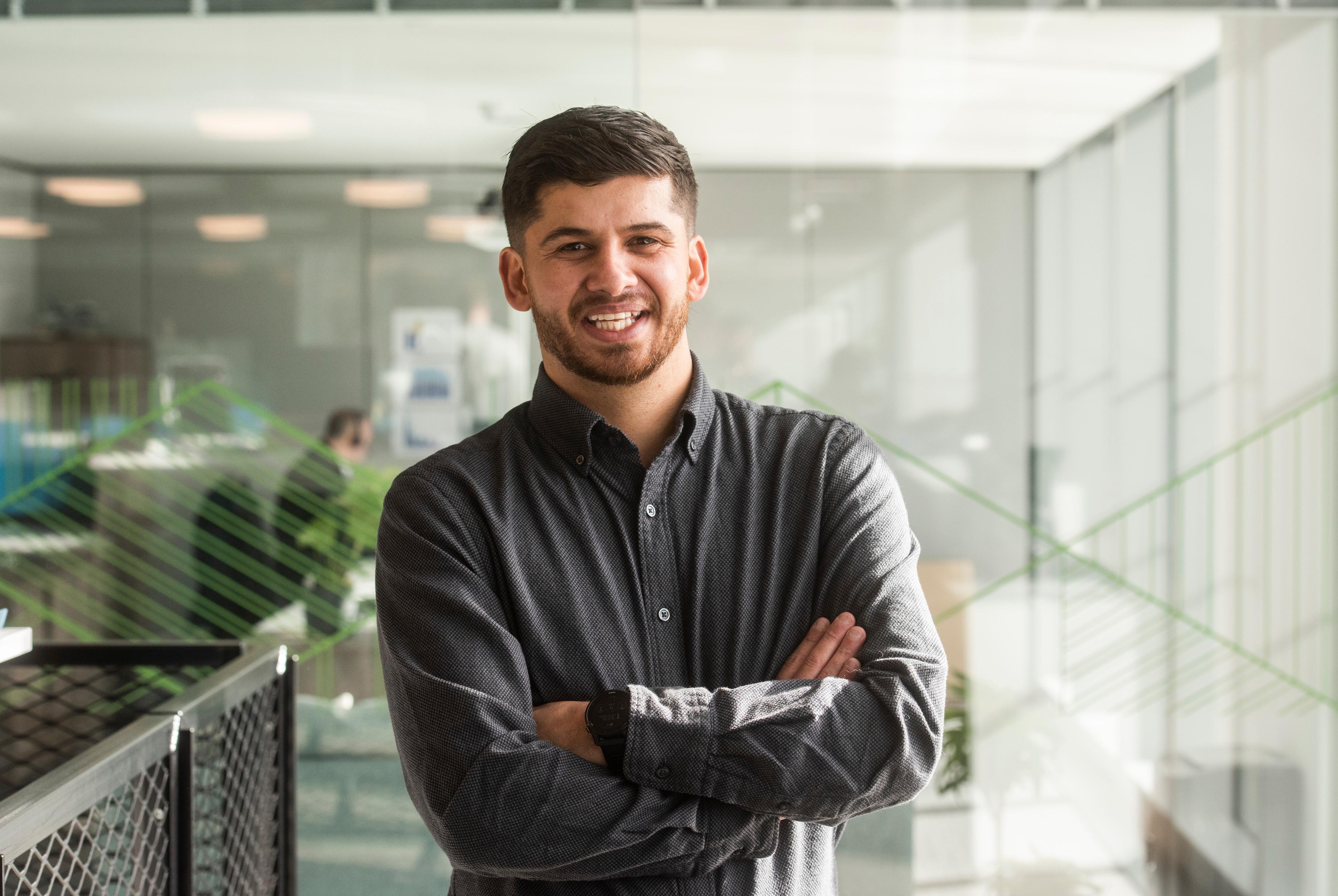 Smiling man in checked shirt crossing arms